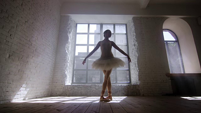 女芭蕾舞演员在有大窗户的阁楼式工作室练习视频素材