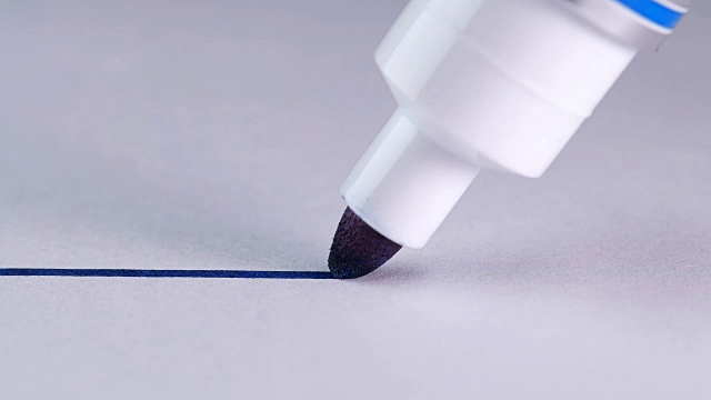 人们用蓝色的记号笔在白色的纸上画一条直线视频素材
