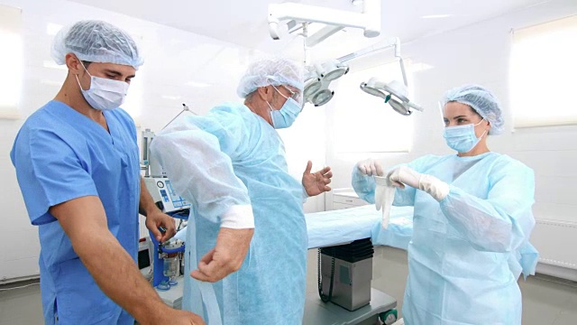 护士和助理在手术室给手术服敷料视频素材
