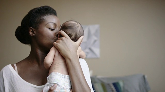 美丽年轻的非洲裔母亲抱着她的混血女婴视频下载