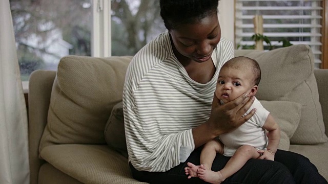 迷人的非洲裔母亲打嗝她的混血婴儿女儿视频素材
