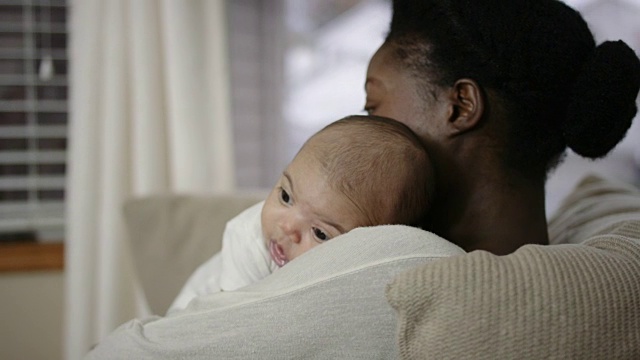 美丽的混血女婴倚靠在非裔美国母亲的肩膀上视频素材
