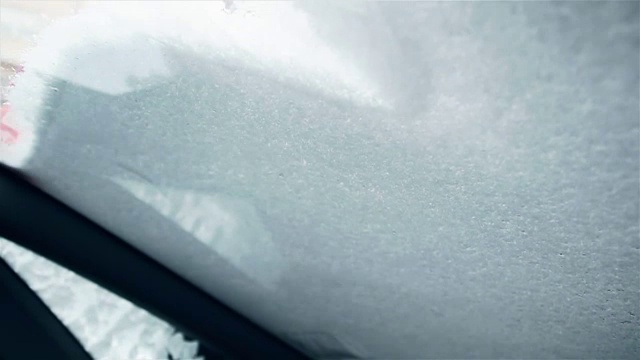 正在清理汽车挡风玻璃上的雪的女人视频下载