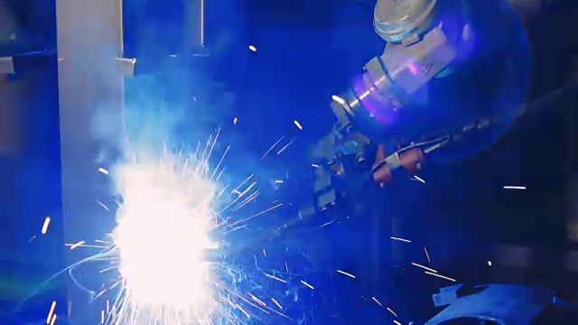 自动化焊接。工业机器人手臂活跃于工厂。近距离视频素材