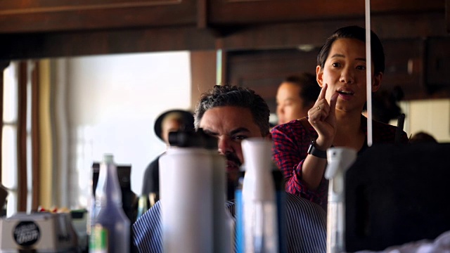 女理发师和顾客在理发店讨论理发视频素材