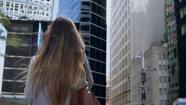 在纽约金融区工作的年轻女商人用手机聊天的背影。慢动作视频素材