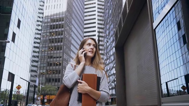 年轻忙碌的女商人一边打电话一边在纽约金融区工作。缓慢的莫视频素材