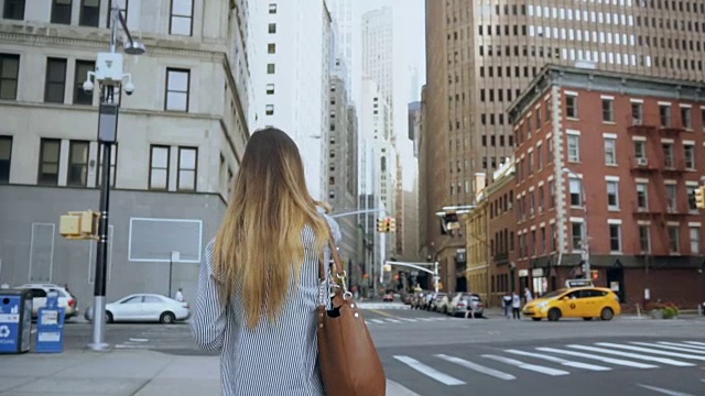 年轻时尚的女商人正在穿过美国纽约金融区的马路。慢动作视频素材