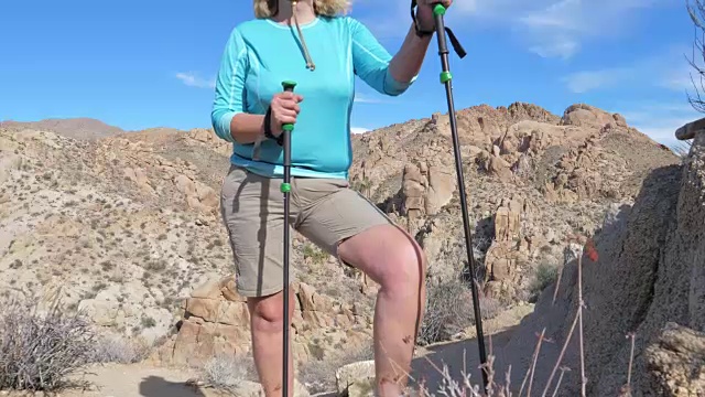 一个疲惫的女游客停下来在沙漠上休息的特写视频下载