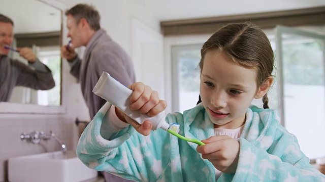 快乐女孩把牙膏贴在4k牙刷上视频素材