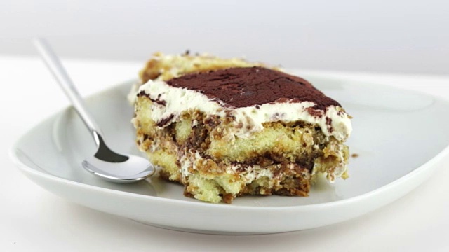 美味的自制提拉米苏蛋糕，传统的意大利甜点在白色的背景上，移动相机，营养保健视频下载