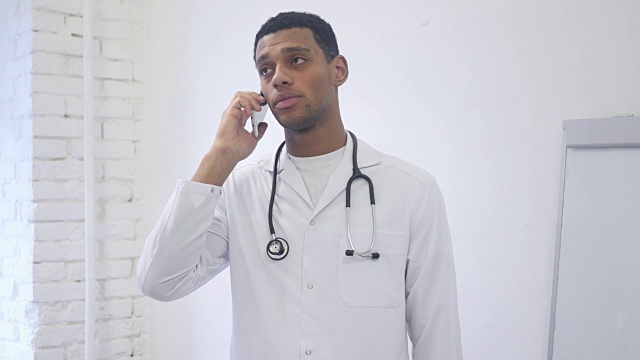 站着的非裔美国医生在医院里用手机打电话视频素材