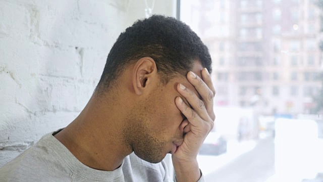 非裔美国青年头痛的特写，窗口视频素材