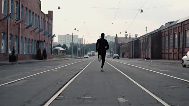 2在1。一个男人在老城的街道上跑得很快。真正的时间。自由的概念。镜头紧跟在年轻运动员身后视频素材