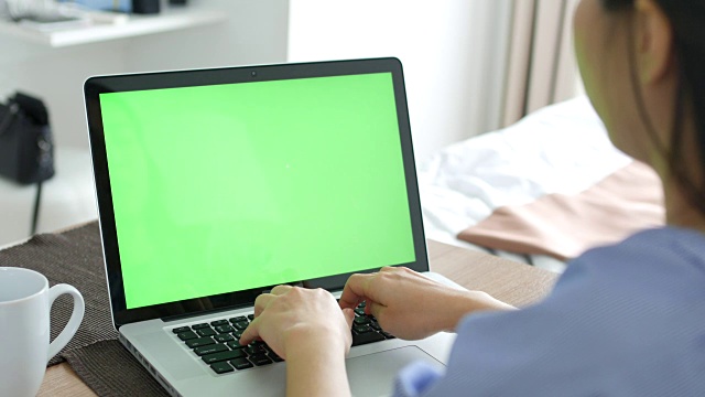 年轻女子在电脑的绿屏上工作视频素材