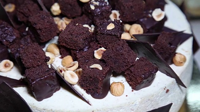 美味的新鲜蛋糕与坚果和巧克力旋转桌子特写。视频下载