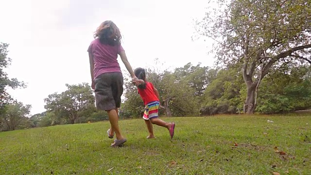 妈妈和女儿在公园里跑步的慢镜头。视频素材