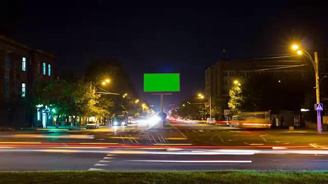 以城市交通为背景的长时间曝光的绿色屏幕广告牌。时间流逝。视频素材