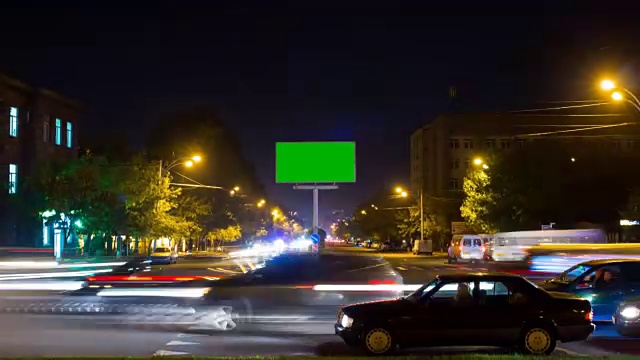 以城市交通为背景的长时间曝光的绿色屏幕广告牌。时间流逝。摄像机移开了视频下载
