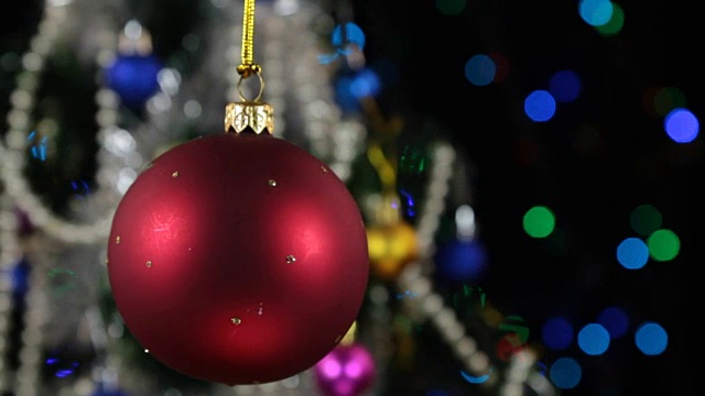 漂亮的红色新年和圣诞节装饰球在绳子上沉重的摆动视频下载