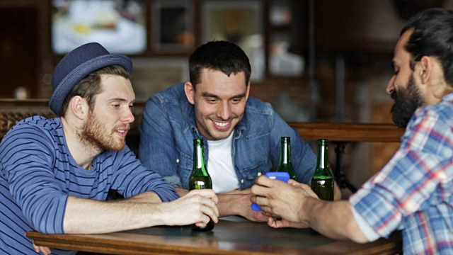 男性朋友拿着智能手机在酒吧或酒吧喝瓶装啤酒视频下载