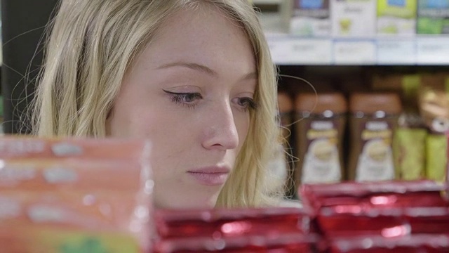 一位年轻女子在杂货店里看产品视频下载