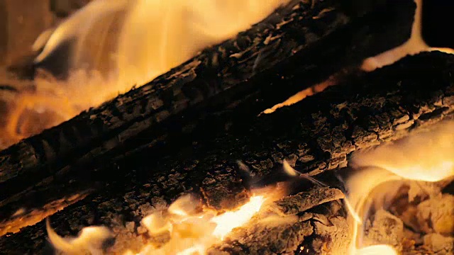 慢镜头:一只男性的手的特写镜头打开了壁炉门，里面有慢慢燃烧的木头。视频下载