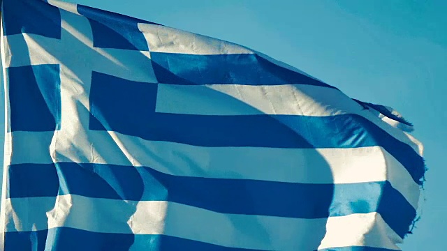 慢镜头:一面希腊国旗在蓝天的风中飘扬的特写。视频下载