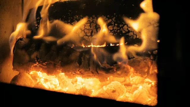 慢镜头:特写一大块木头在壁炉里慢慢燃烧。视频下载