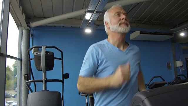 老人在健身房健身，在跑步机上慢跑视频素材