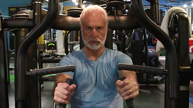 老年人在上半身健身器上做力量训练视频素材
