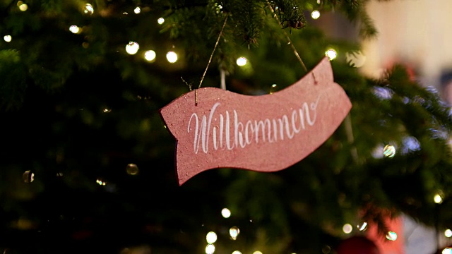 克拉科夫的圣诞树上挂着一块牌子，上面写着欢迎的字样，翻译成德语视频素材