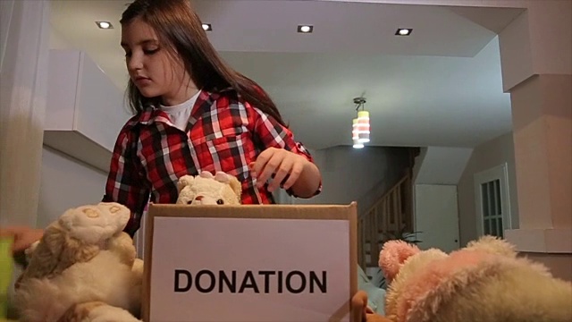 十几岁的女孩把玩具放在捐款箱里给其他孩子视频下载