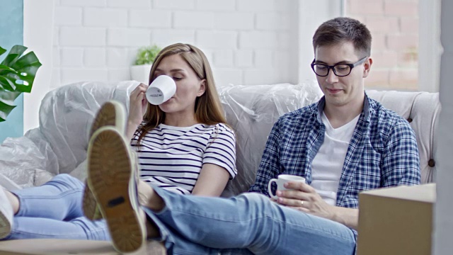 年轻夫妇在沙发上喝咖啡视频素材