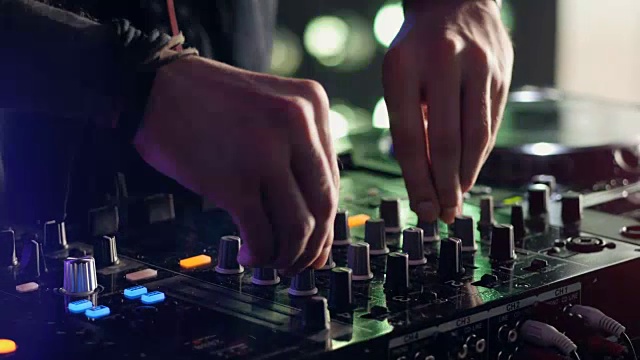 特写镜头。手的DJ调整各种轨道上的DJ混音控制台在夜总会派对。视频素材