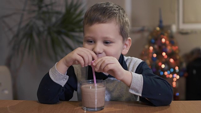 孩子在家里用吸管喝着美味的饮料视频素材