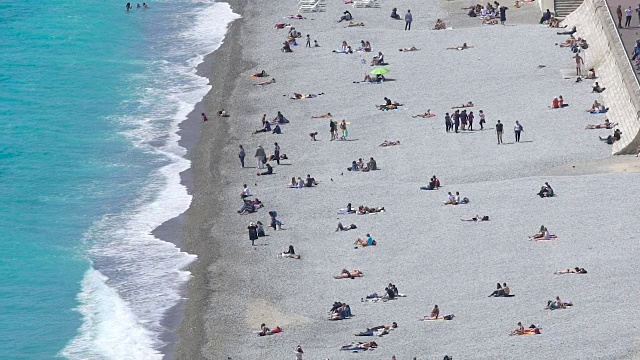人们在尼斯的海滩上晒太阳和放松，旅游和度假视频素材