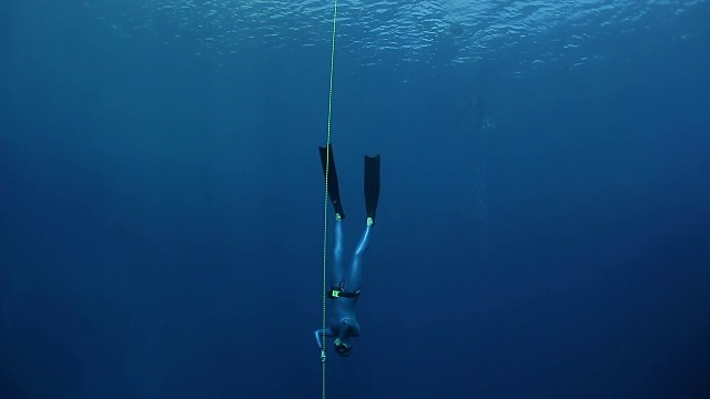 女自由潜水员沿着绳索在海里下降视频素材