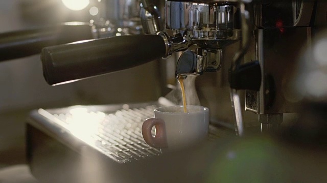 咖啡师从咖啡机端了一杯咖啡到桌子上视频素材