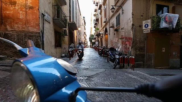 那不勒斯的居民骑着摩托车和摩托车在狭窄的街道上行走视频素材