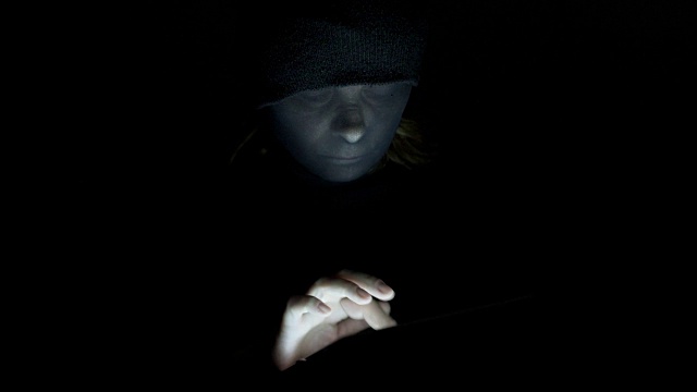 戴面具的女性黑客在平板电脑上打字视频下载