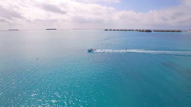 无人机拍摄的一名男子在热带岛屿附近滑水。视频素材