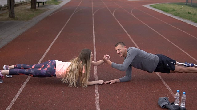 年轻的截肢运动员和他的女朋友做平板支撑视频下载