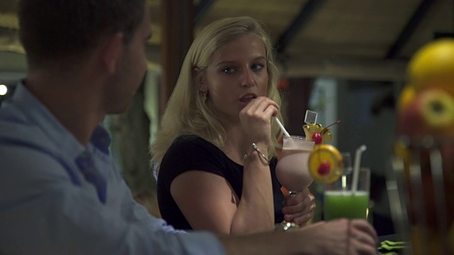 一对男女在度假胜地的酒吧里喝酒。视频素材