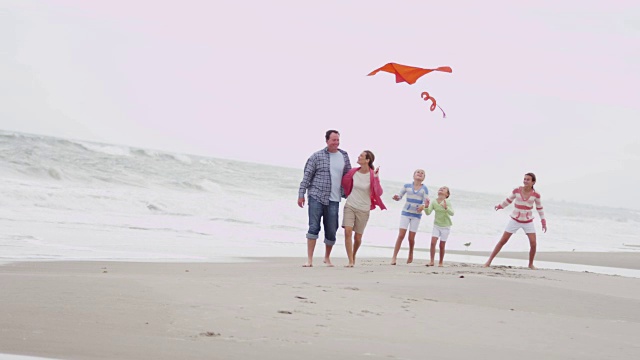 快乐的白种人家庭在户外沙滩上放风筝视频素材