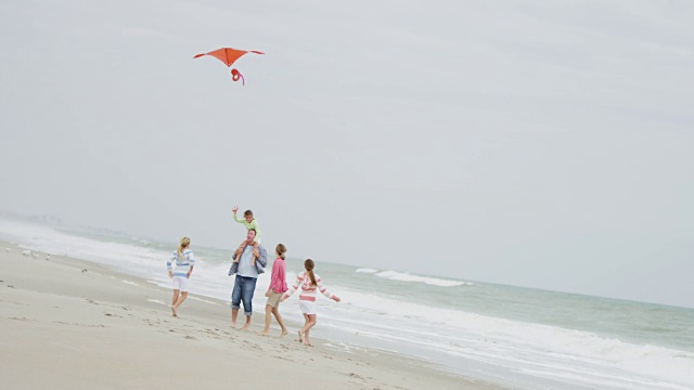 赤脚白人家庭有乐趣的海滩风筝视频素材