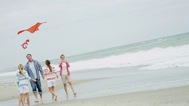 健康的白人家庭玩玩具风筝落海滩视频素材