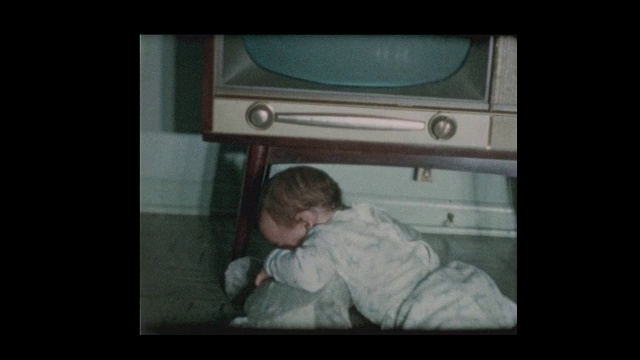1960年，可爱的小男孩检查古董电视机视频素材