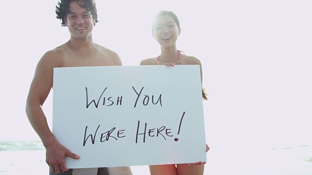 快乐的民族夫妇展示假期问候白板视频素材