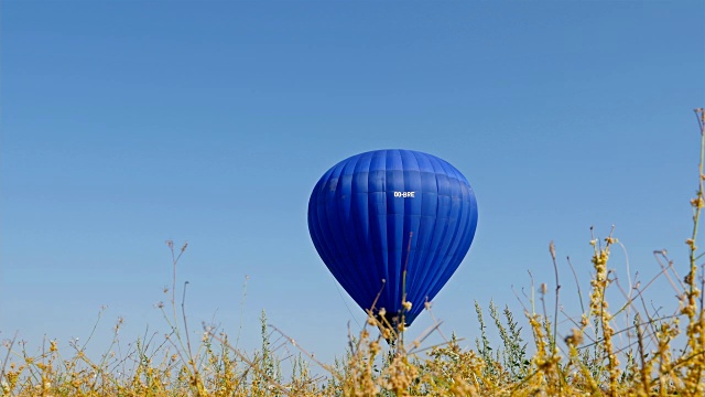 蓝色的热气球在蓝天的背景下飞行视频素材